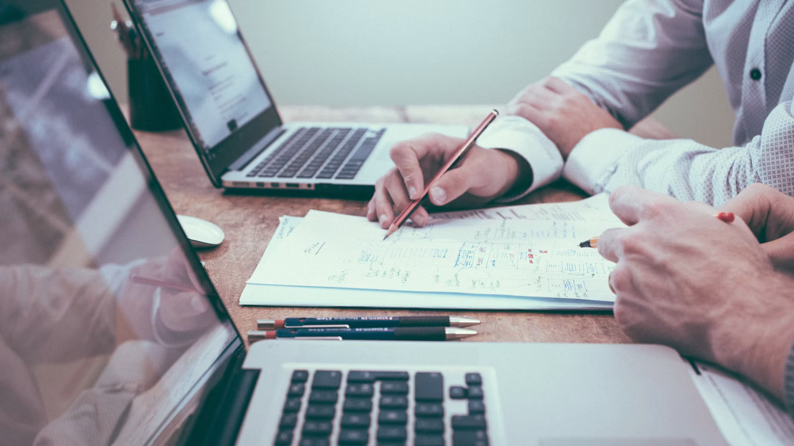 Top AI Calling App - team reviewing evaluation checklist on laptops