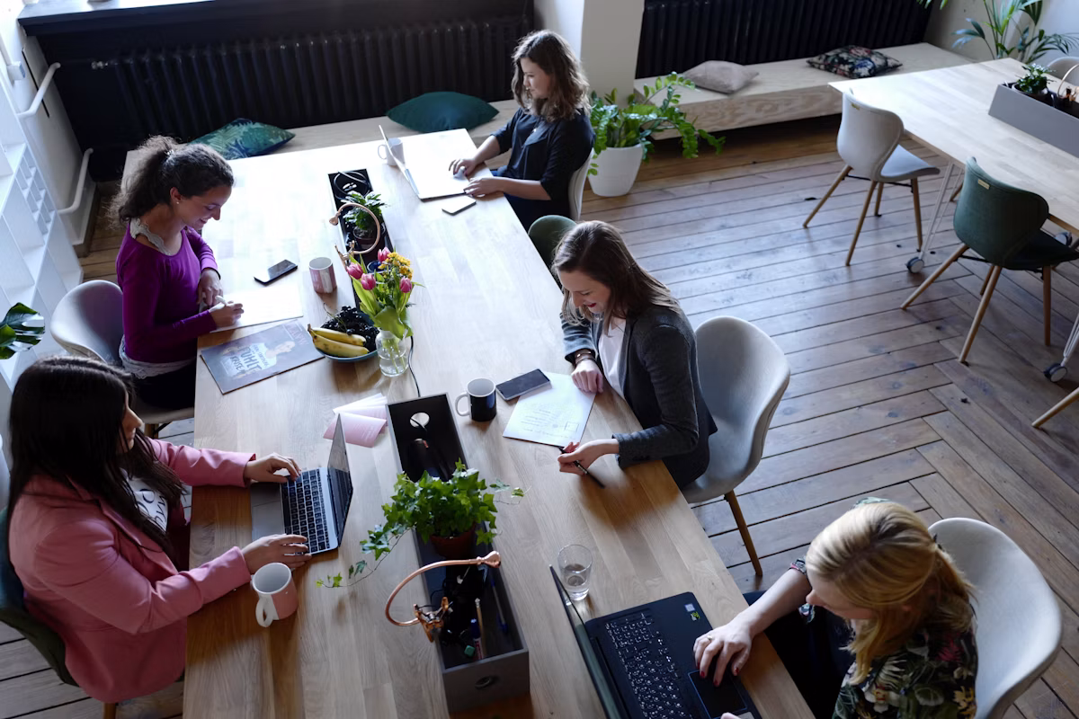 A team working together at a long shared table in an open office